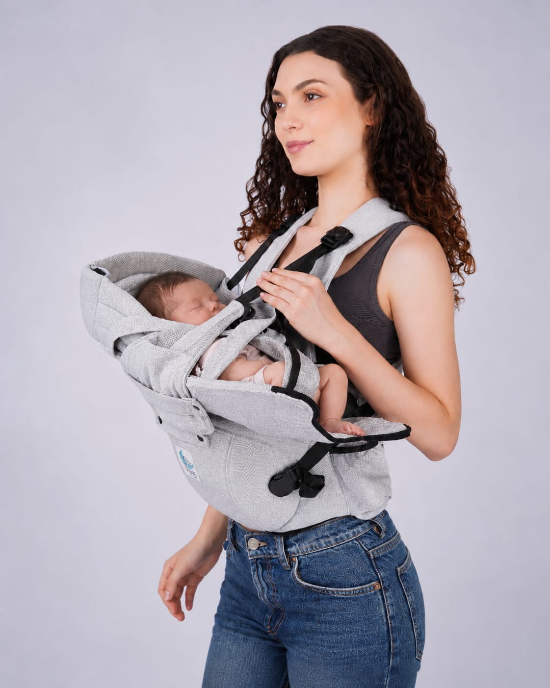 Bibzy baby carrier shown in the signature newborn cradle position